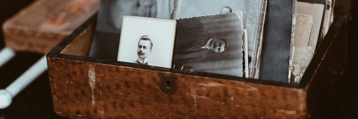 Old printed photographs in a wooden box